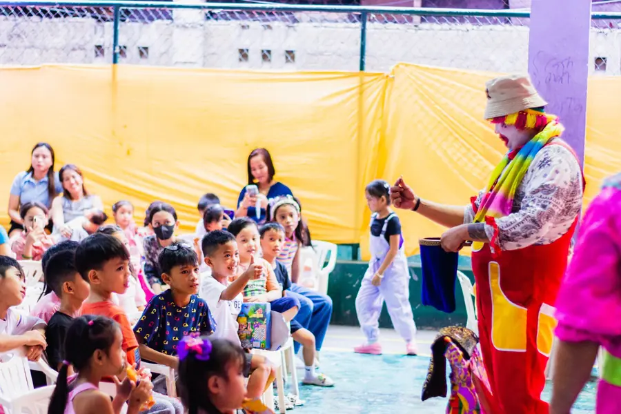 Clown che fa un gioco di magia davanti ai bambini seduti