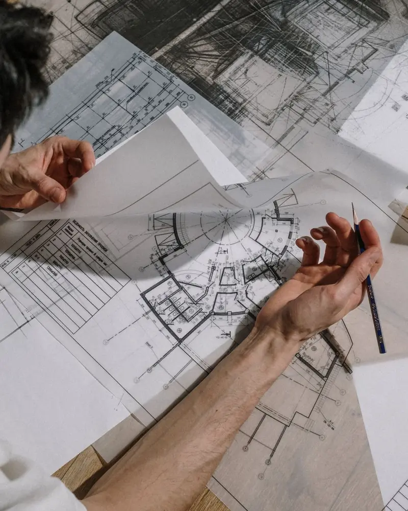 Architetto che disegna a mano sulle tavole del progetto