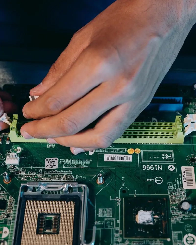 Mani del tecnico che montano i componenti sulla scheda madre