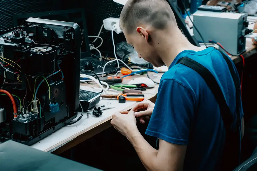 Tecnico al banco di riparazione dei computer