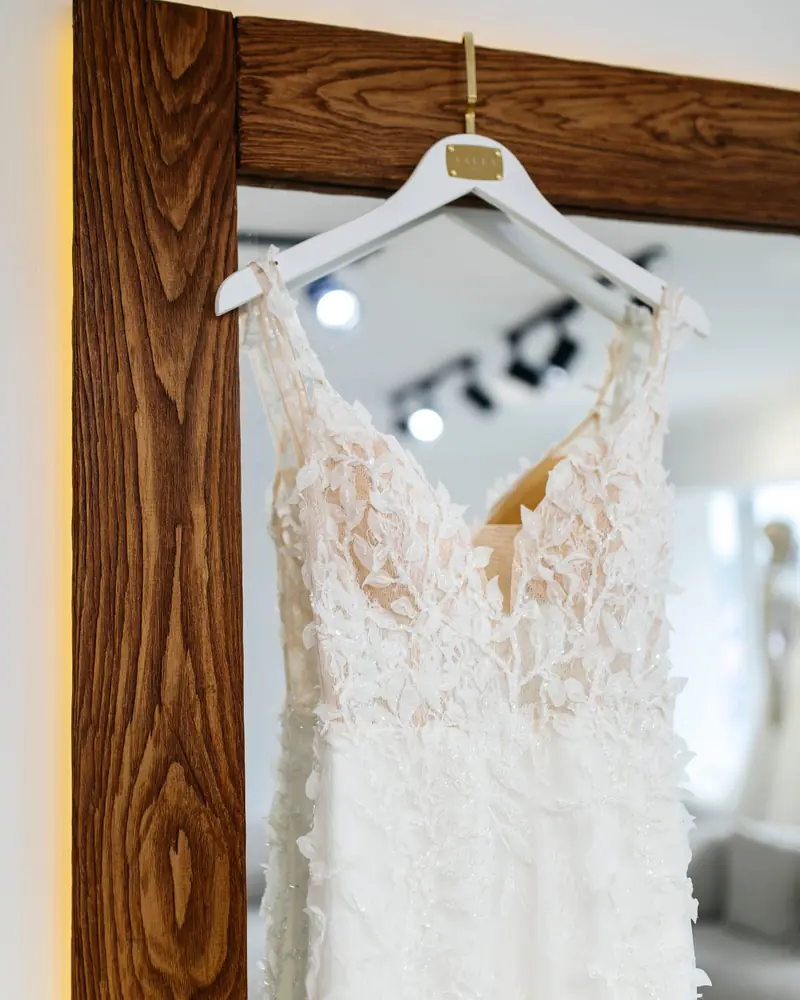 Abito da sposa in pizzo appeso in atelier