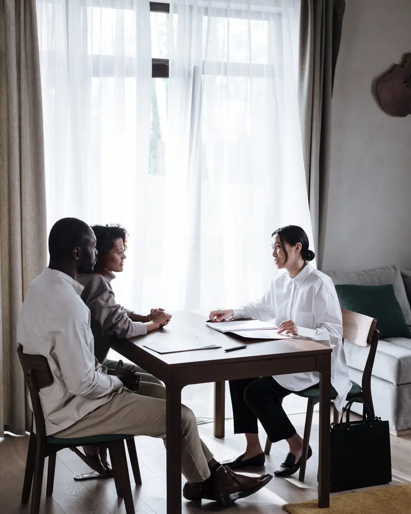 Consulenti al tavolo con i clienti in una stanza luminosa