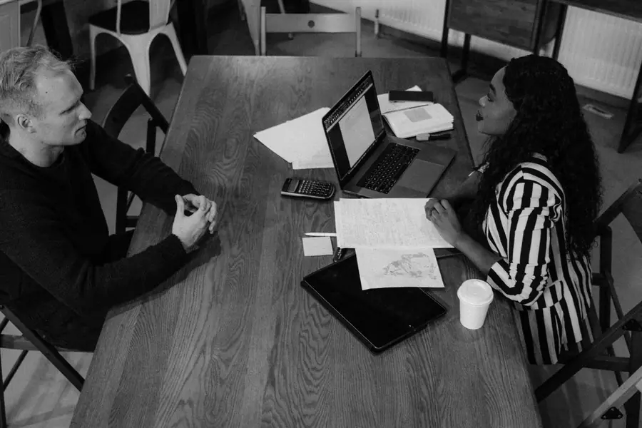 Riunione di lavoro a un tavolo, con il portatile e gli appunti