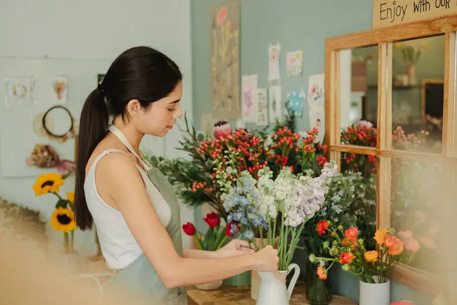 Fiorista che sistema i fiori nel negozio