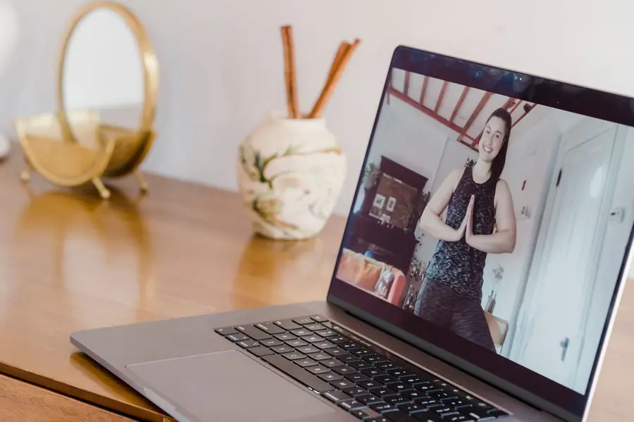 Lezione di yoga online sul portatile, sulla scrivania di casa