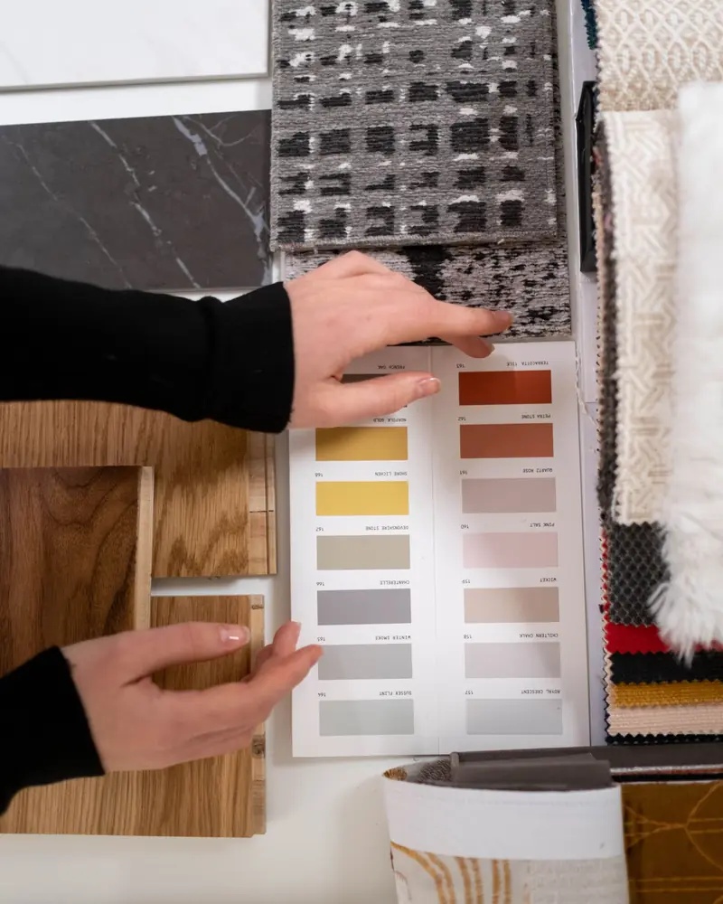 Mani che scelgono campioni di colori e materiali per un progetto d'interni