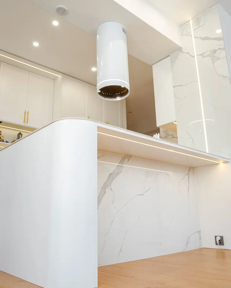 Cucina con il piano e la parete in marmo bianco venato