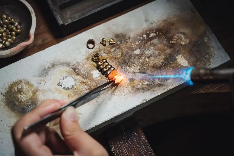 Saldatura di un anello con il cannello, sul banco dell'orafo