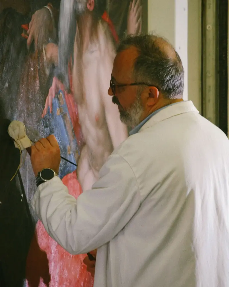 Restauratore che ritocca un dipinto antico con il pennello
