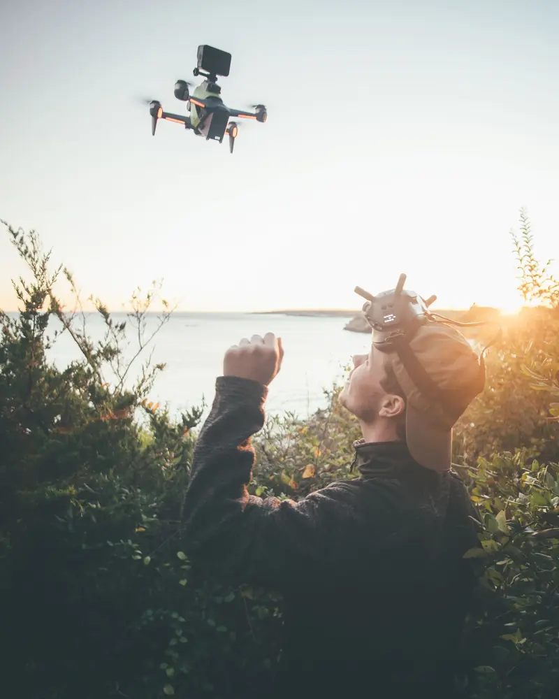 Pilota che fa volare un drone al tramonto