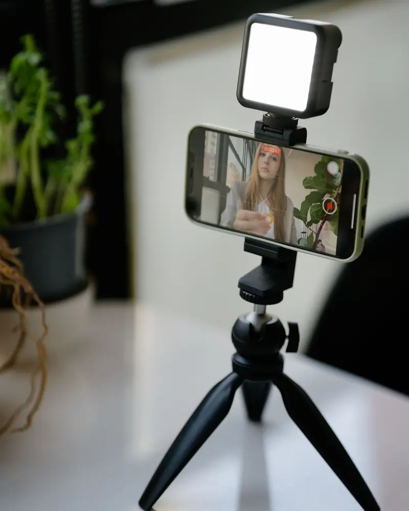 Telefono sul treppiede con la luce, pronto per registrare un video