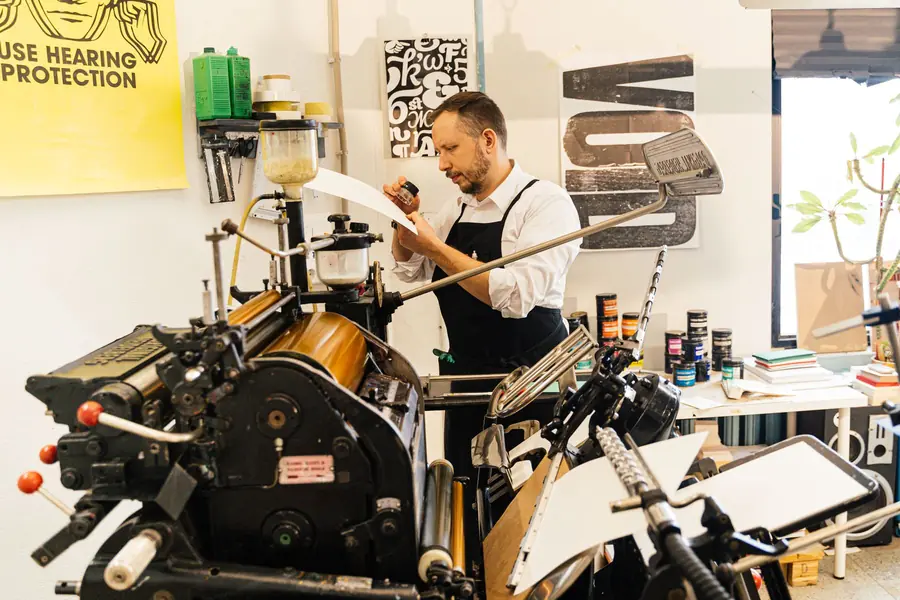 Stampatore al lavoro alla macchina tipografica