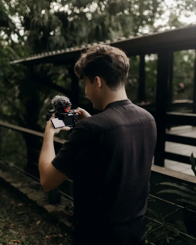 Videomaker di spalle che riprende con la camera su stabilizzatore